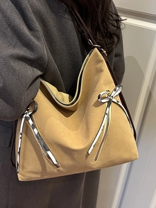 Large capacity khaki tote bag with zipper details and bow accent shown on model