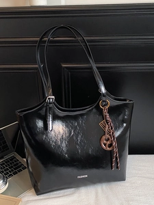 Large black glossy tote bag with FASHION text and brown knot charm for daily commuting