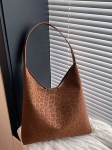 Brown leopard print suede tote bag with minimalist Hobo silhouette on white lace fabric