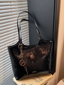 Black glossy high-capacity tote bag with fashion text detail and brown knot charm