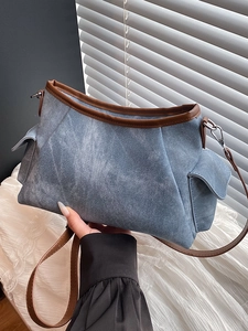 Blue washed denim shoulder bag with brown leather trim and adjustable strap for women