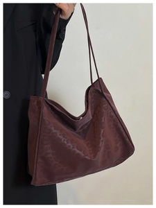 Shoulder tote bag in deep burgundy with subtle leopard pattern shown on a model