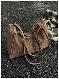 Close-up of leopard print tote bag with soft suede texture on asphalt background