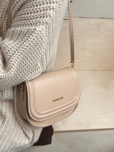 Elegant beige saddle shoulder bag with gold Fashion text on smooth leather for women