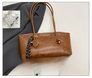 Detail of vintage brown leather tote bag with knot element and decorative silk scarf accessory