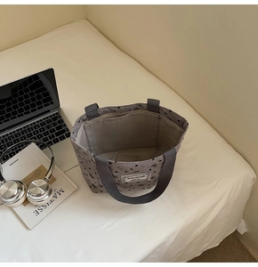Corduroy tote bag interior view with laptop and headphones on a bed setup