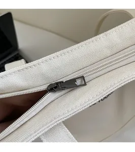 Detail of premium canvas tote featuring a high-quality metal zipper and durable texture