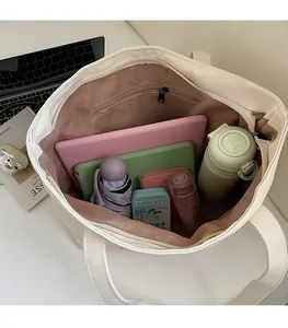 Detailed interior of the canvas tote bag showing spacious compartments for laptop and gear