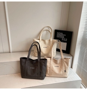 Three minimalist canvas tote bags in black, beige and khaki colors with BE YOURSELF print