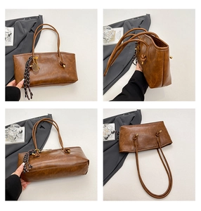 Detail view of brown leather tote bag with unique knot shoulder strap and plaid scarf