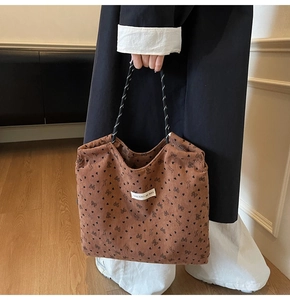 Detail of vintage brown corduroy tote bag featuring heart print and woven handles