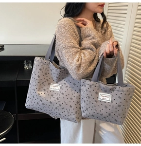 Detail showing two sizes of gray patterned tote bags with ribbed fabric texture