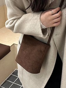Minimalist dark brown matte suede bucket bag for women styled with a beige cashmere coat