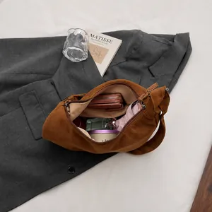 Top view of large brown suede shoulder bag with essentials showing spacious interior