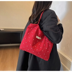 Detailed close-up of a red floral canvas tote bag showing soft fabric texture and patterns