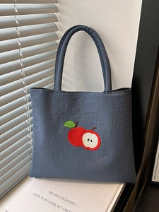 Blue nylon tote bag with red apple embroidery and textured fabric for daily use