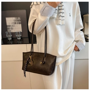 Dark brown vintage leather tote bag with metal key pendant and checkered ribbon detail