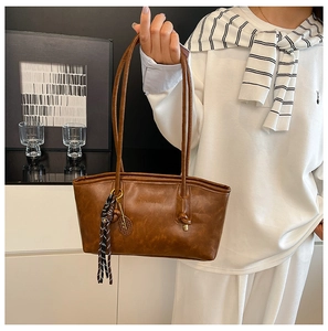 Detailed close-up of brown vintage faux leather tote with silk scarf and tennis charm