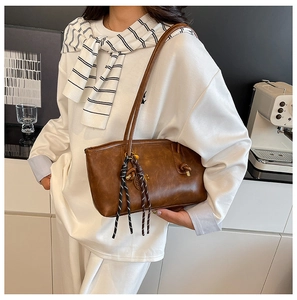 Brown vintage leather tote bag shown on a model in a cozy minimalist home studio