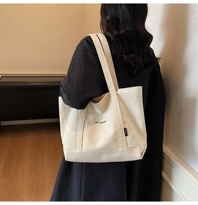 Detail view of Be Yourself printed canvas tote bag worn on shoulder for minimalist style