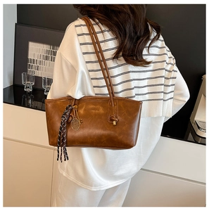 Detail of vintage brown tote bag with oily leather texture and tennis racket charm