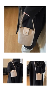 Close-up of woven texture beige bucket bag with adjustable shoulder strap details