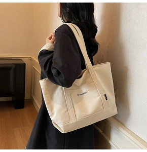 Detail showing the 'BE YOURSELF' typography on high-quality off-white canvas tote bag