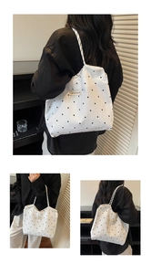 Detail of large canvas tote bag with black star pattern and dual rope handles
