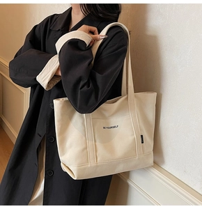 Detail of printed BE YOURSELF lettering on a beige canvas tote bag for women
