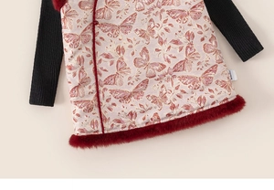 Dettaglio del gilet in broccato rosa con farfalle rosse e rifiniture in ecopelliccia