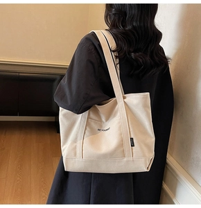 Beige canvas tote bag detail featuring Be Yourself print and durable shoulder strap