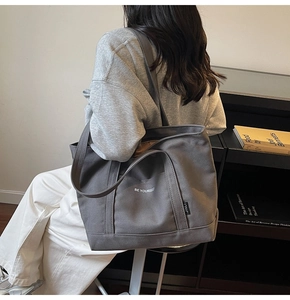 Macro detail of high-quality dark grey canvas tote bag with Be Yourself print and strap