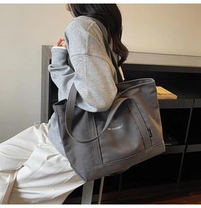 Detail of dark grey canvas tote bag with Be Yourself print and adjustable shoulder strap