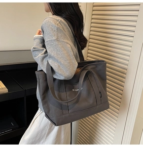Detail view of dark grey canvas tote bag with white BE YOURSELF lettering print