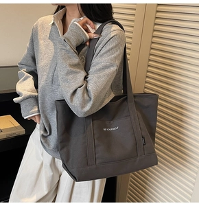 Detail view of durable canvas tote bag with BE YOURSELF print and large storage capacity
