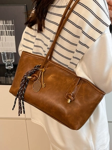 Vintage brown leather tote bag with silk scarf and tennis racket charm accessory