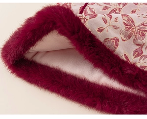 Dettaglio macro di ecopelliccia rossa e jacquard a farfalla su vestito da bambina