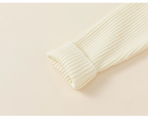 Detailed macro view of cream rib-knit cuffs with exquisite craftsmanship and soft texture