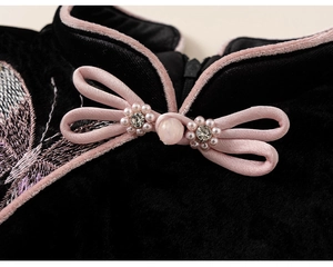 Detail of Chinese style collar with pink bow buckle and butterfly embroidery on black velvet