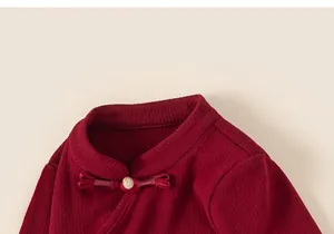 Dettaglio di top rosso per bambini con bottone tradizionale e trama a maglia a coste