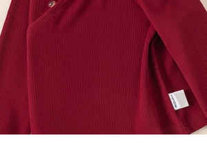 Dettaglio dell'abito cheongsam rosso scuro per bambini con scollo e bottone laterale
