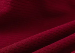 Dettaglio della spessa trama a costine in maglia rosso scuro per abiti invernali bimbi