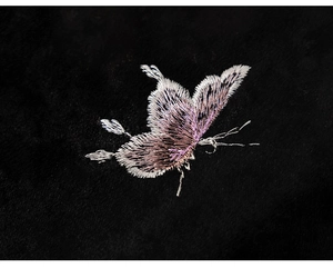 Macro shot of detailed pink butterfly embroidery on black velvet fabric for girls' dress