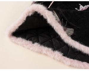 Detail of pink butterfly embroidery and plush trim on black velvet winter garment