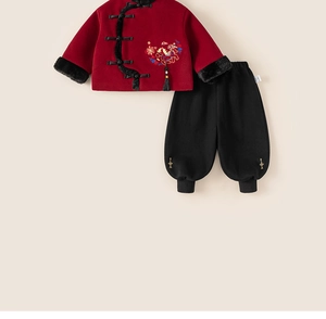 Detail of red Chinese New Year boy suit featuring traditional embroidery and faux fur trim