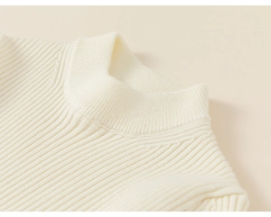 Close-up of cream knit sweater showing vertical ribbed texture and high round neckline