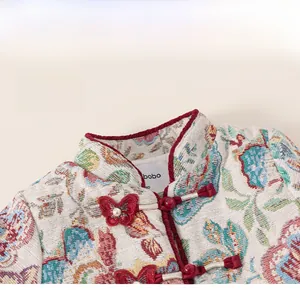 Macro detail of Chinese style stand-up collar with butterfly frog button and floral jacquard