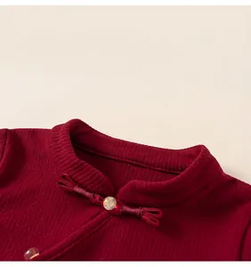 Dettaglio del colletto alla coreana con bottone tradizionale su maglia bordeaux