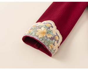 Dettaglio macro della manica in maglia bordeaux con ricami floreali in pizzo eleganti