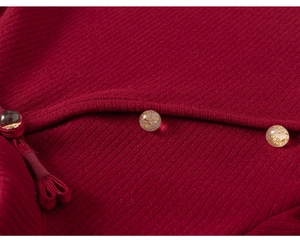 Dettaglio abito in maglia a coste rosse con bottoni cinesi tradizionali e resina con foglia d'oro